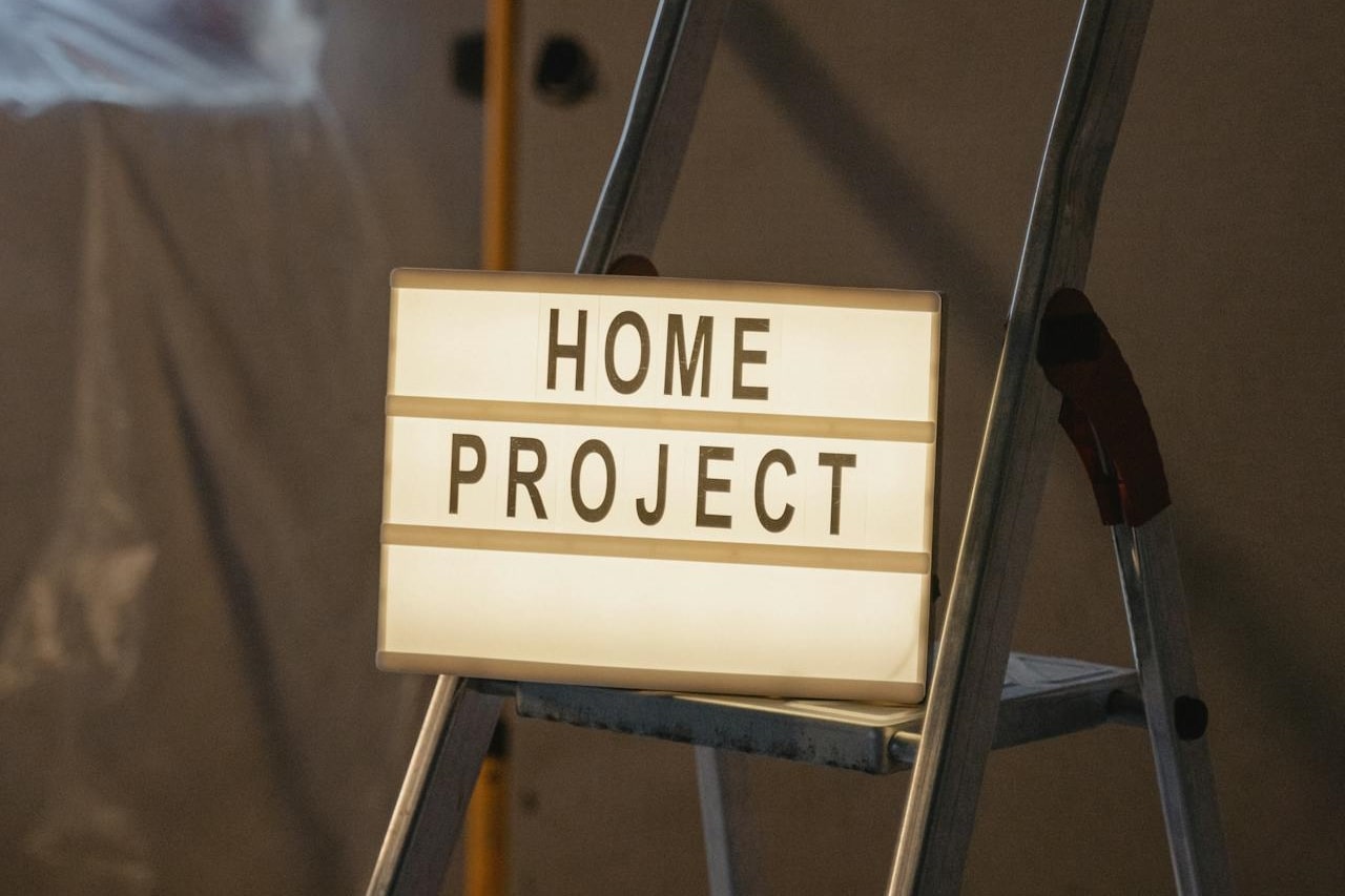 Leuchtschild mit Aufschrift Home Project auf Leiter